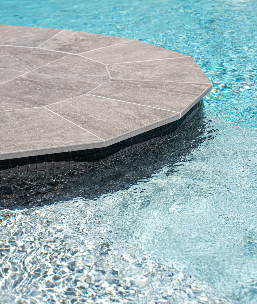 Pool renovation with Pebblecrete and porcelain tile coping